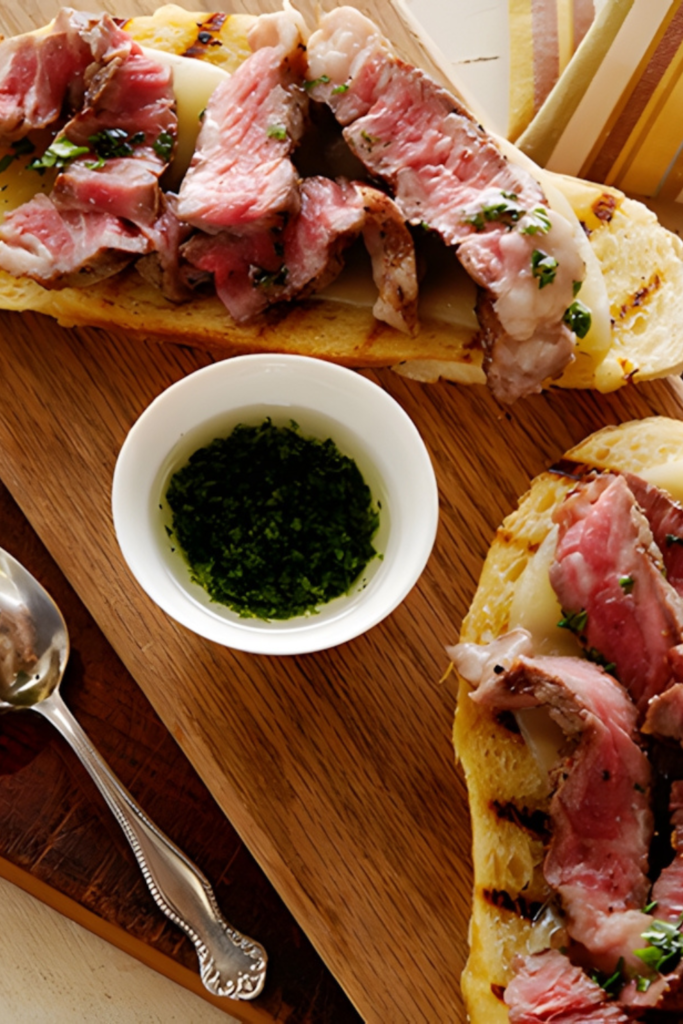 Mini Open Faced Steak Sandwiches on Garlic Bread with Aged Provolone and Parsley Oil