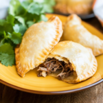 Beef And Goat Cheese Empanada With Piquillo Pepper Sauce And Pickled Red Onion